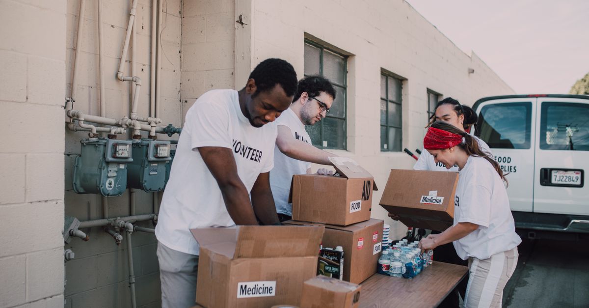 Volunteers sort and prepare donations outdoors for a charitable event.